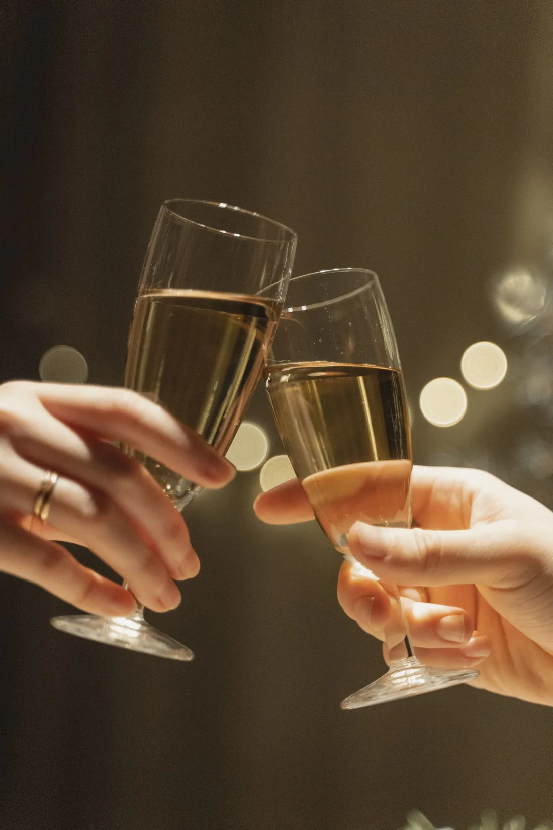 Mains levant des verres gravés lors d'un toast de mariage